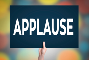 Applause sign held up by hand.