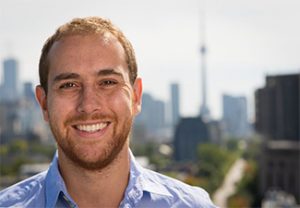 Head shot of a smiling Doug Campbell in front of a Toronto skyline
