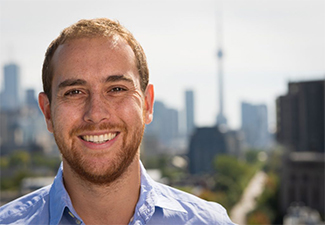 Head shot of a smiling Doug Campbell in front of a Toronto skyline