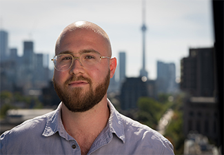 Head shot of Evan Taylor in front of a Toronto skyline