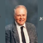 On a gray background, an image of Jack Stevenson, a white-haired white man in a suit smiling into the camera. Around him the words: "In memoriam John (Jack) T. Stevenson, 1932-2024"