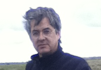 Man with windswept hair wearing a sweater outside