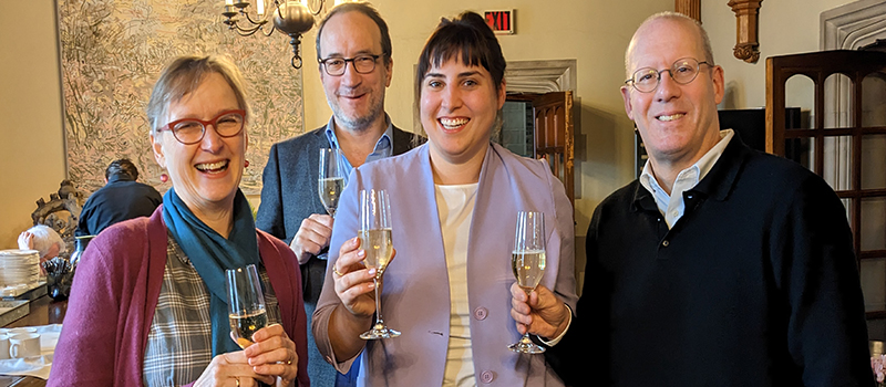 From left to right: Marleen Rozemond, Martin Pickavé, Michaela Manson, and Donald Ainslie smiling broadly and holding champagne glasses in a restaurant
