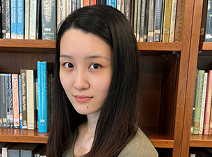 Woman with shoulder length hair in front of bookcase