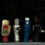 Line of various human-figured robots on a black background
