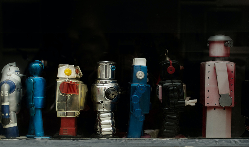 Line of various human-figured robots on a black background