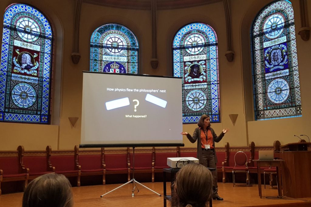 Female speaker in front of a projector facing an audience in Victoria College