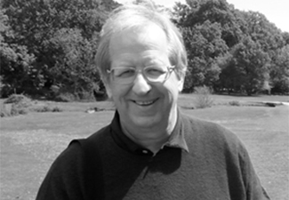 Black-and-white image of Stephen Houlgate wearing a sweater standing in the English countryside