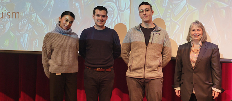 From left to right, Elysa Din, Mathieu Duguay, Thomas Kaufman-Nash, and Rachel Barney in front of the 2022 World Philosophy Day lecture slides of Agnes Callard