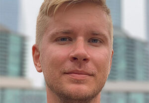 Close crop of Viacheslav Zahorodniuk, a blond white man with a stubbly beard, against an urban background