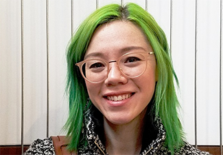 Woman with green hair and glasses.