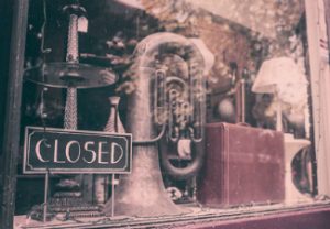 A closed sign hangs in the window of an old jazz instrument shop